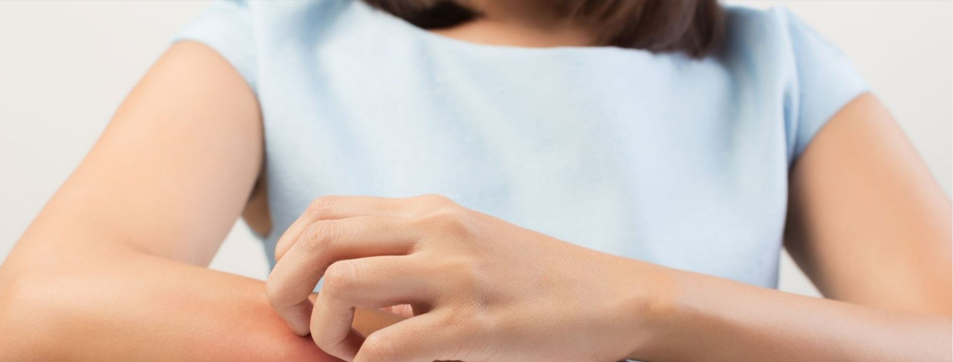 Kvinna kliar sig på armen